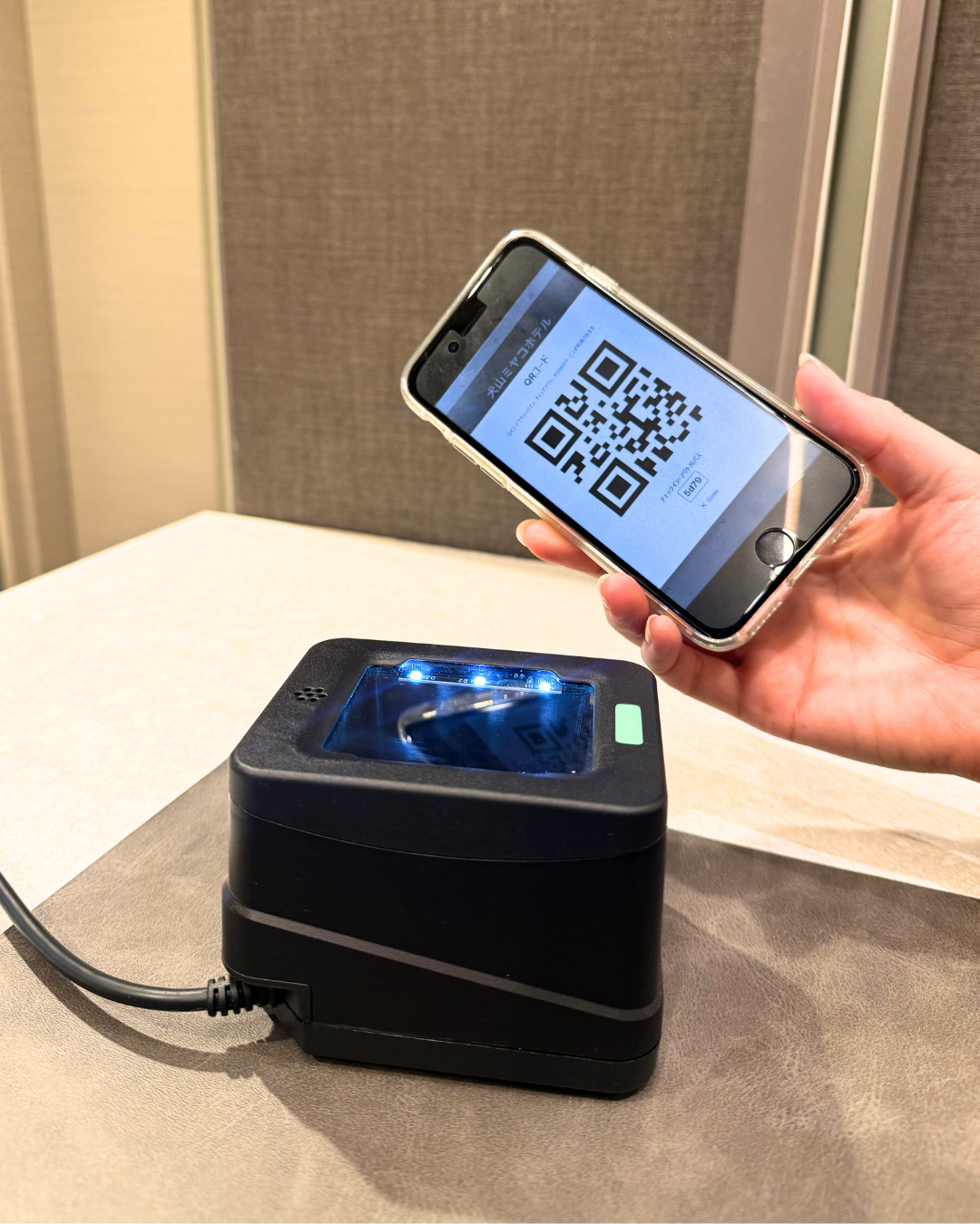 スマートフォンでQRコードを提示している様子